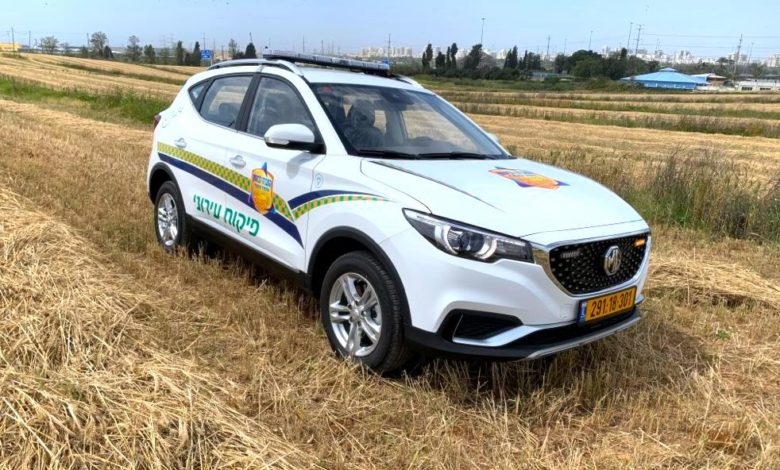 ניידת לפיקוח עירוני חשמלית מסוג MG ZS EV בצבע לבן עם כיתוב של עיריית ראשון לציון בשדה