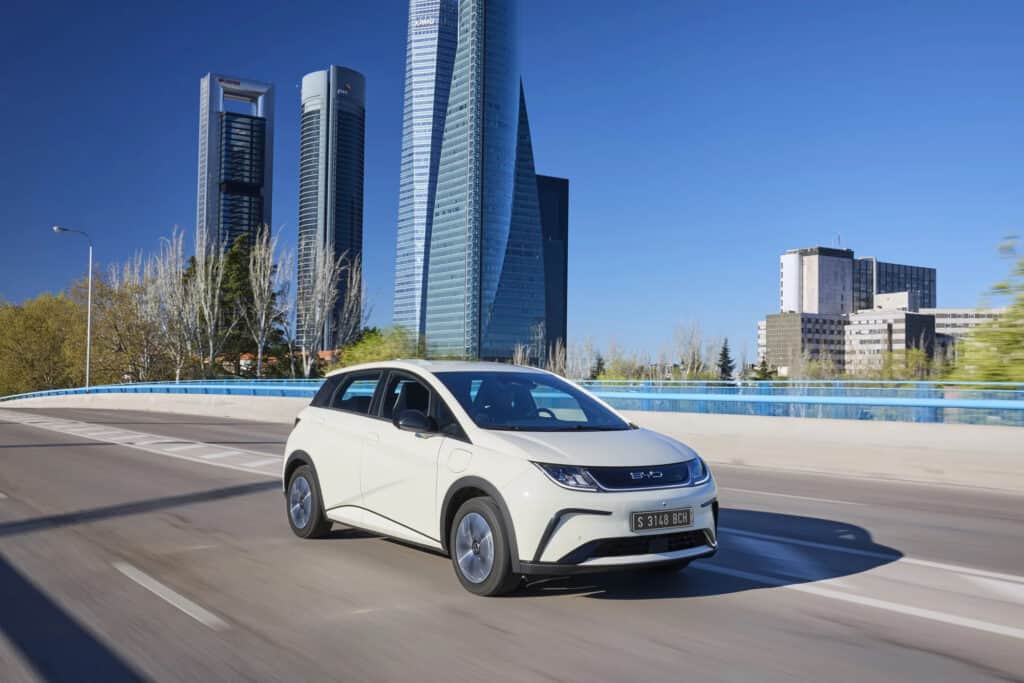 BYD דולפין לבנה בנסיעה על גשר BYD דולפין לבנה בנסיעה על גשר עם רקע עירוני