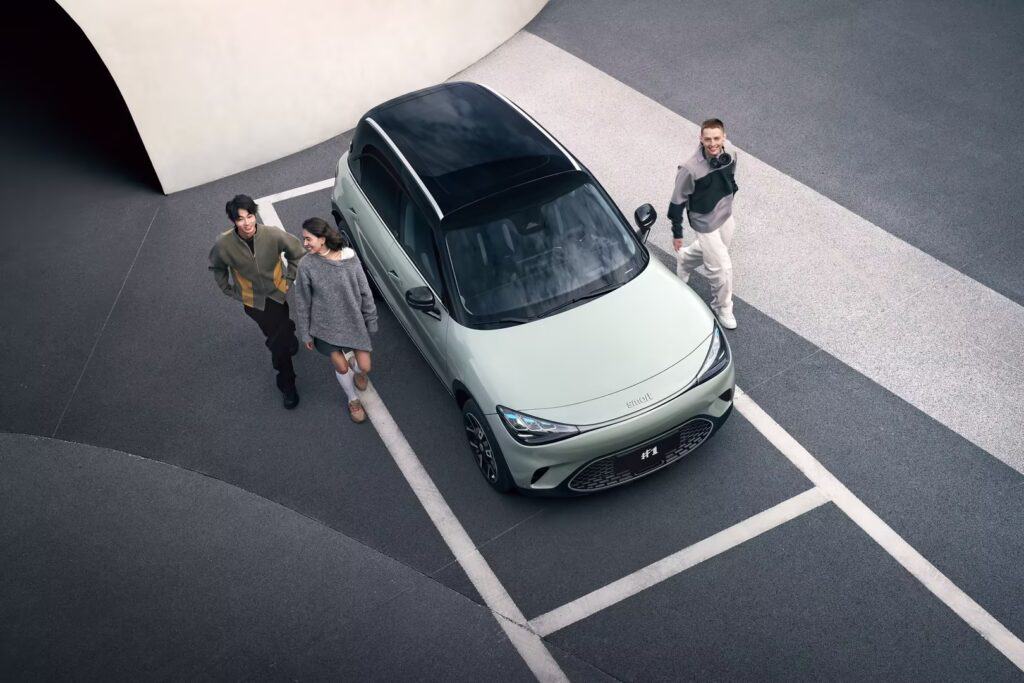 מבט ממעוף הציפור על אנשים עומדים ליד סמארט #1 בחניה