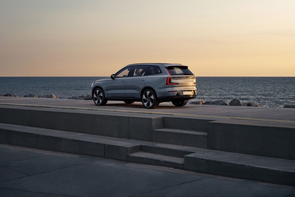 מבט צד על וולוו EX90 על טיילת הפונה לים לקראת שקיעה