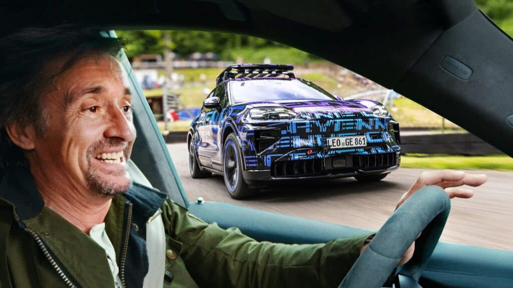 ריצ׳רד האדמונד נוהג על פורשה קאיין חשמלית עם נגרר ומדבקת הסוואה