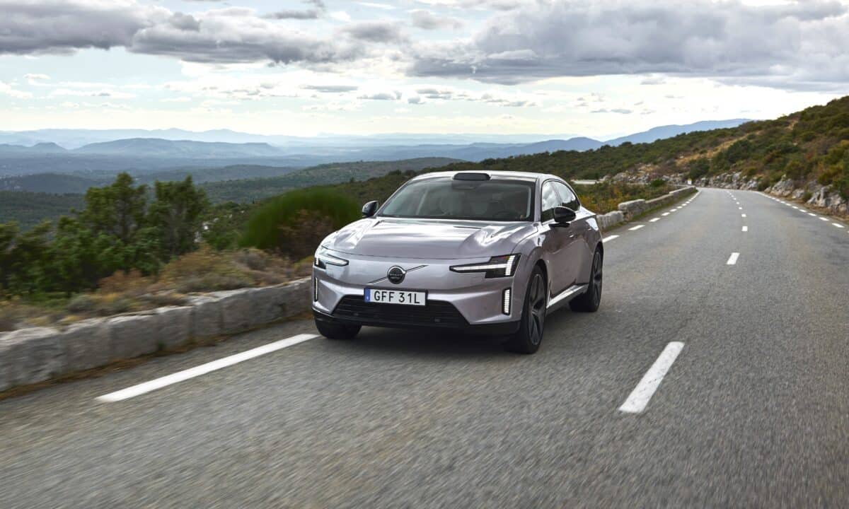 מכונית סאלון וולוו ES90 בצבע אפור נוסעת בכביש בינעירוני בנוף של טבע