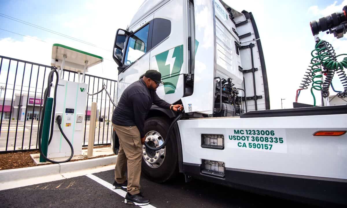 נהג משאית מחבר משאית חשמלית לעמדת טעינה ייעודית