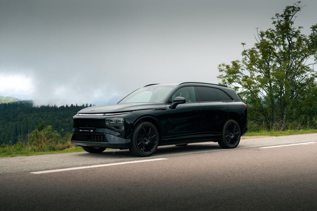 אקספנג G9 שחורה בנסיעה על כביש באיזור ירוק