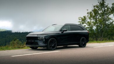 אקספנג G9 שחורה בנסיעה על כביש באיזור ירוק